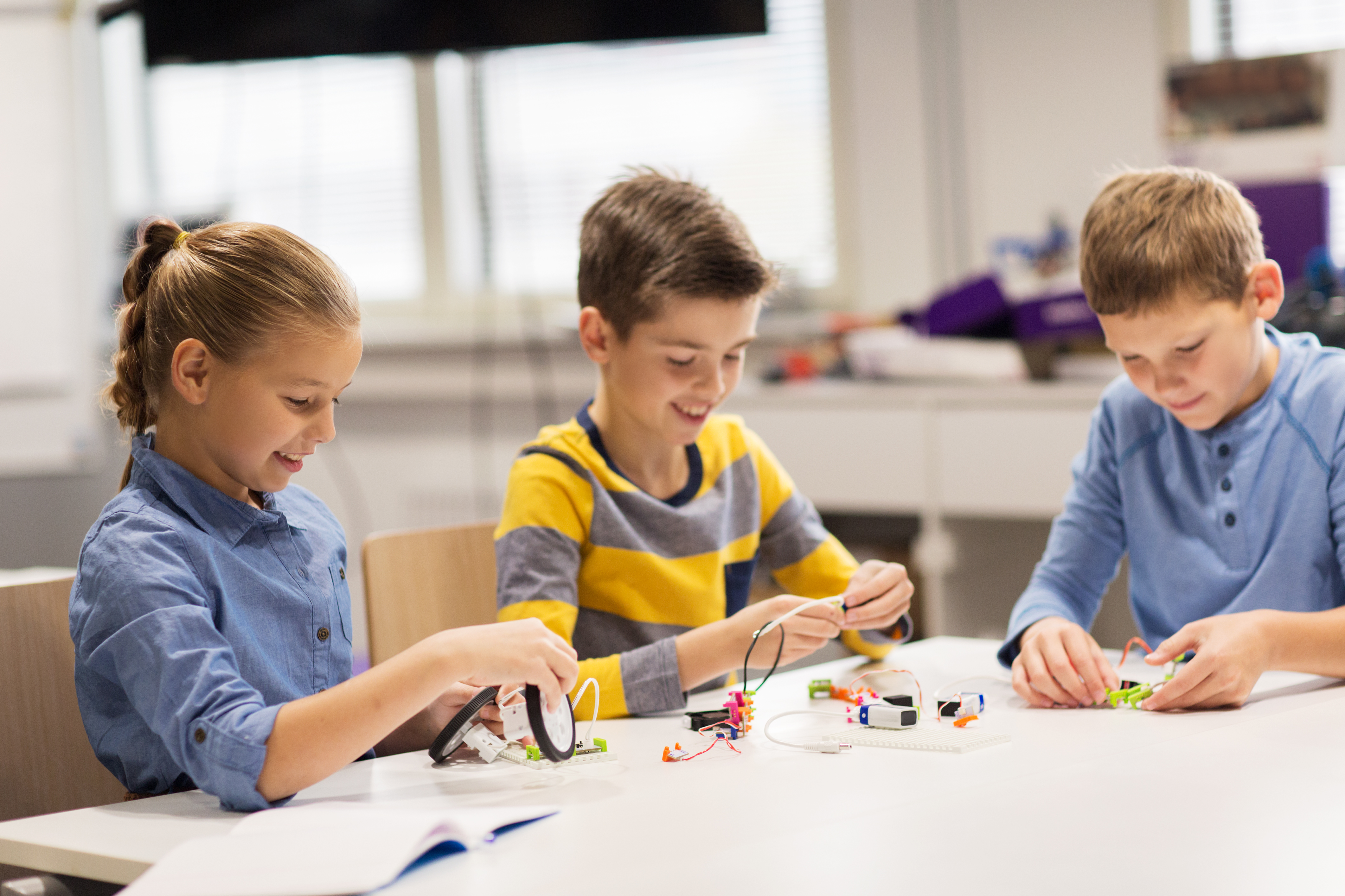 happy children building robots at robotics school – Momgineer